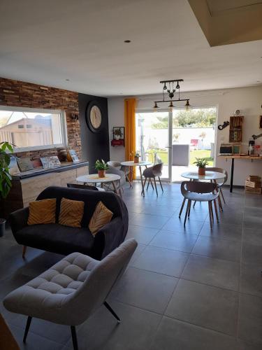 a living room with a couch and chairs and tables at Chambres 2 caps in Ambleteuse