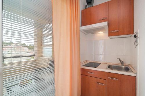 a small kitchen with a sink and a window at Apartments Molo Mare in Hvar