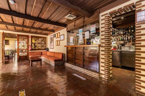 a bar with a couch and a counter in a room at Casablanca Unique Hotel in Monte Gordo