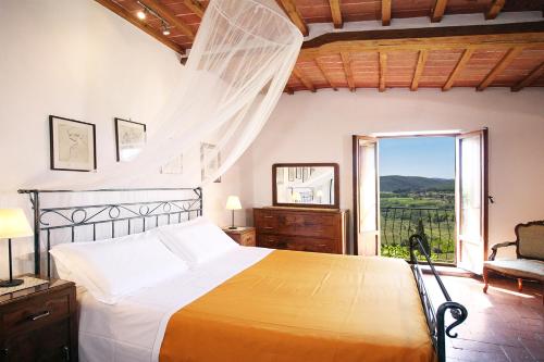 ein Schlafzimmer mit einem Bett und einem großen Fenster in der Unterkunft Stuart Apartments in Montepulciano