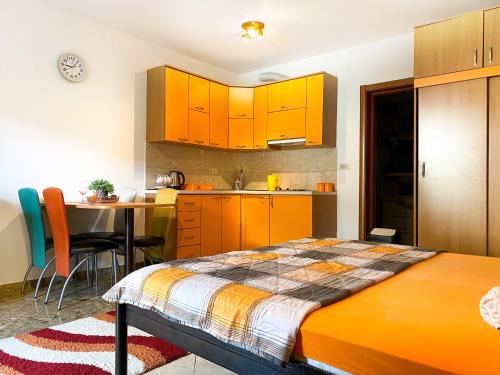 a kitchen with orange cabinets and a bed in a room at Apartment Green Building in Sveti Stefan