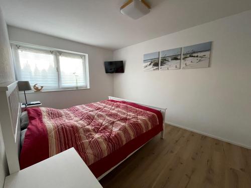 ein weißes Schlafzimmer mit einem Bett und einem Fenster in der Unterkunft Ferienwohnung Deifel in Schömberg