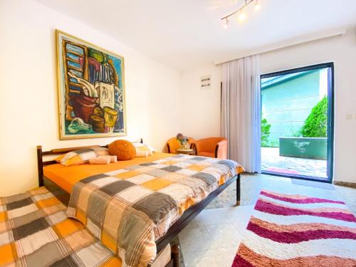 a bedroom with a bed and a large window at Apartment Green Building in Sveti Stefan