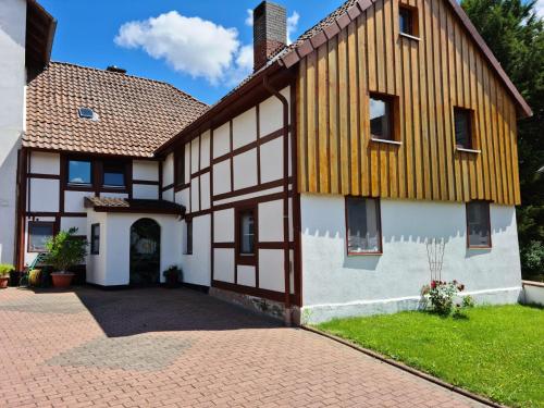 a large white and brown house with a brick driveway at Ferienwohnung Landliebe in Wegensen