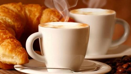 two cups of coffee and croissants on a table at Porto di Mare in Praia a Mare