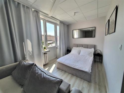a small bedroom with a bed and a couch at Apartamenty Rynek in Białystok