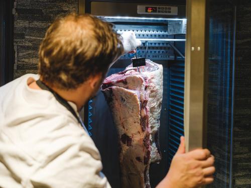a man is looking into an open refrigerator at Hotel Landhaus in Münster