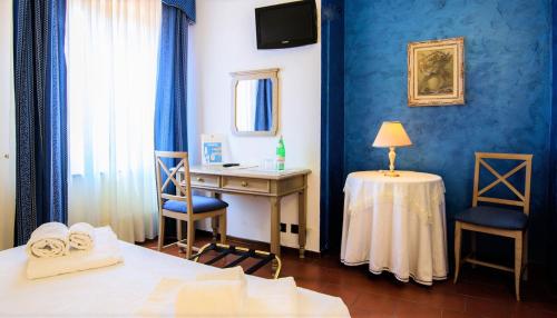 a room with a desk and a bed and a table and chairs at Villa Cavour in Bottanuco