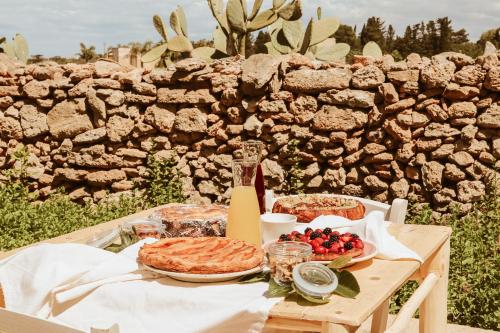 een tafel met taarten en fruit erop bij Masseria Li Foggi in Gallipoli