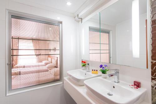 Baño blanco con lavabo y espejo en Prestige Hotel Old City, en Estambul