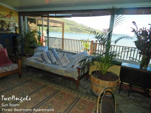 a couch in a room with a view of the water at TwoAngels in Knysna