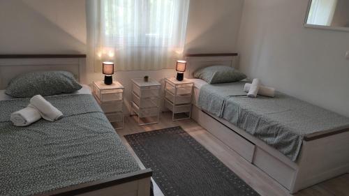 1 dormitorio con 2 camas y 2 mesitas de noche en Kuća za odmor Bebić, Kremena en Klek