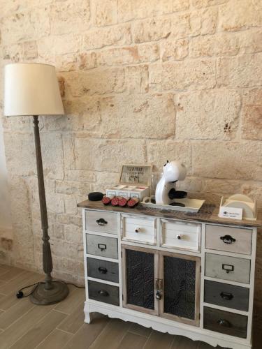 lampa i komoda w pokoju z ceglaną ścianą w obiekcie Nido di pietra-dimora in centro w Alberobello
