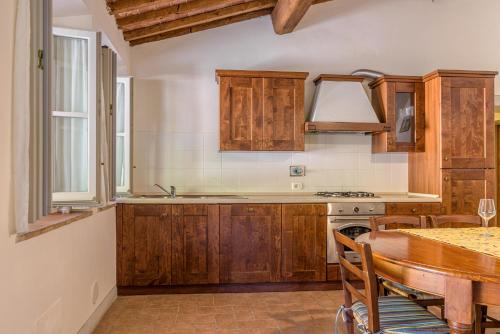 a kitchen with wooden cabinets and a table with a dining room at Agriturismo Concadoro in Castellina in Chianti