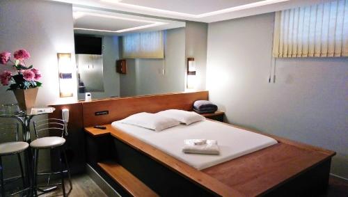 ein Krankenhauszimmer mit einem Bett und einem Spiegel in der Unterkunft Motel Cisne Blumenau (Adult Only) in Blumenau