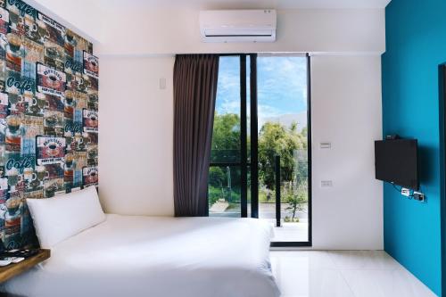 a bedroom with a white bed and a window at 雨禾田 in Sanxing