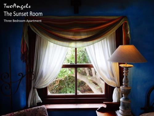 a window with curtains in a blue room at TwoAngels in Knysna