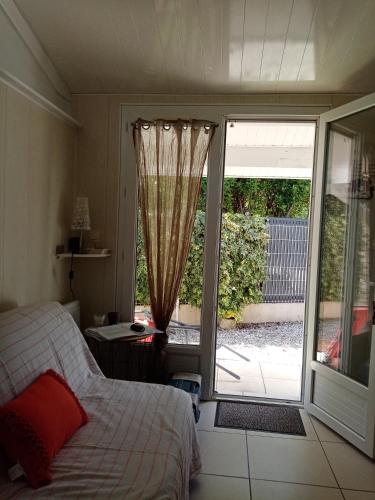 una camera da letto con un letto e una porta scorrevole in vetro di La girolle a Hourtin