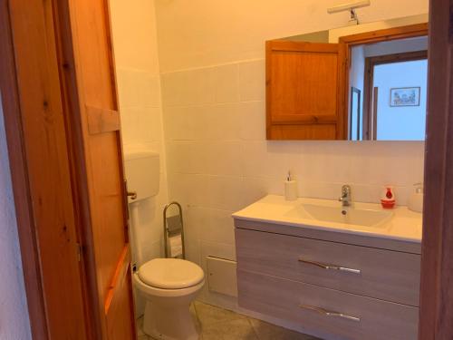 W łazience znajduje się toaleta, umywalka i lustro. w obiekcie Casa Vacanze Monica w mieście Villasimius