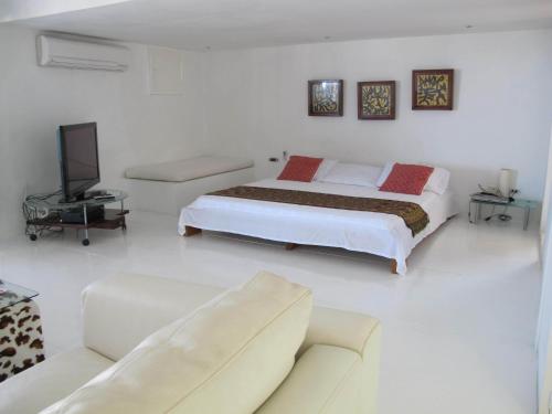 a white bedroom with a bed and a couch at Penthouse Caribbean View and private pool, Cartagena in Cartagena de Indias
