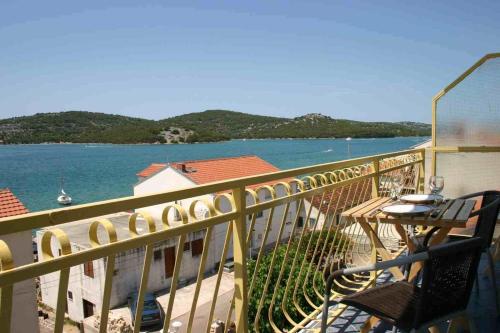 einen Balkon mit Tisch, Stühlen und Wasser in der Unterkunft Villa Stegic in Tisno