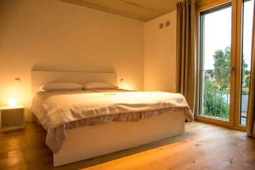 1 dormitorio con cama y ventana grande en Kolbermoor-Schoener-Wohnen, en Kolbermoor