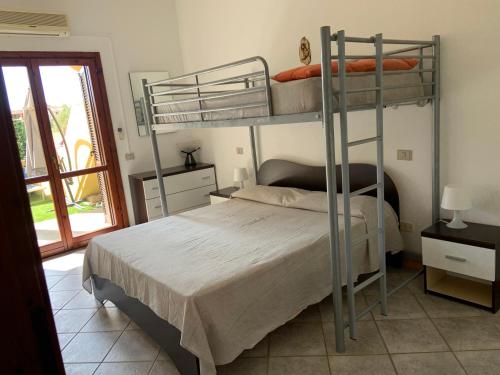 sypialnia z 2 łóżkami piętrowymi i oknem w obiekcie Casa Vacanze Monica w mieście Villasimius