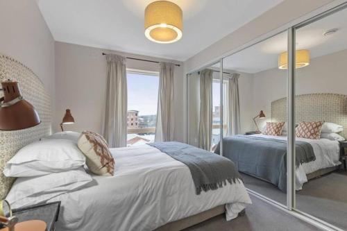 a bedroom with two beds and a large window at 5* Luxury, City Centre, Brand New Development in Belfast