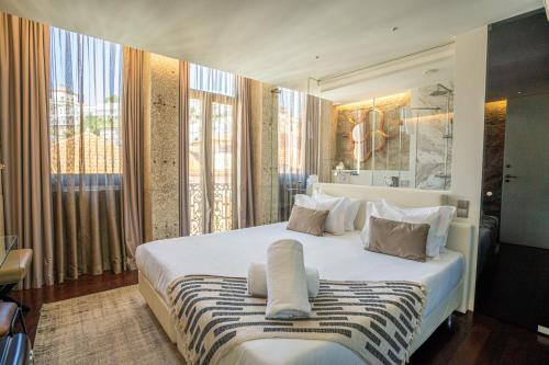 - une chambre avec un grand lit blanc et des fenêtres dans l'établissement CHARM by YoursPorto, à Vila Nova de Gaia