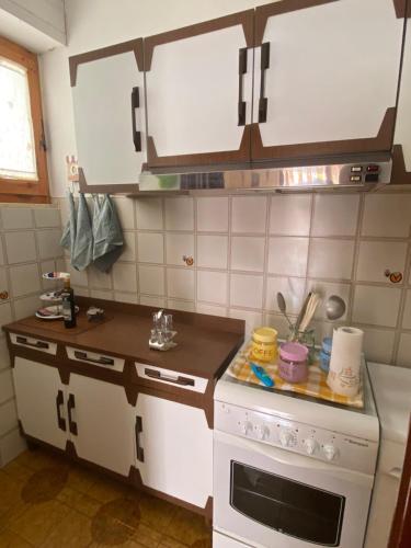 una cucina con piano cottura bianco e forno bianco di Simo House a Follonica