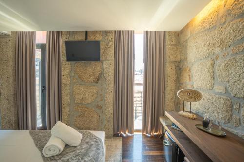 um quarto de hotel com uma cama e uma televisão na parede em CHARM by YoursPorto em Vila Nova de Gaia