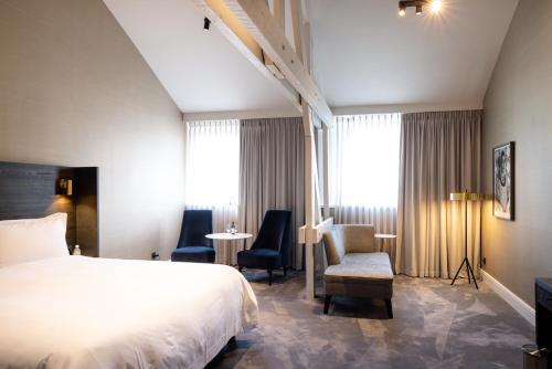 a hotel room with a bed and a table and chairs at Pillows Grand Boutique Hotel Reylof Ghent in Ghent