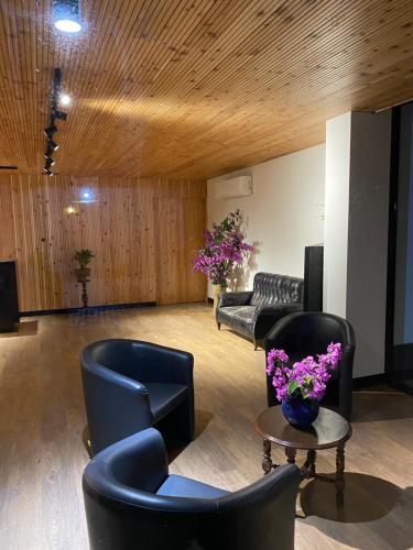 a lobby with chairs and a table with purple flowers at Solar Do Conde Garden Hotel in Capelas