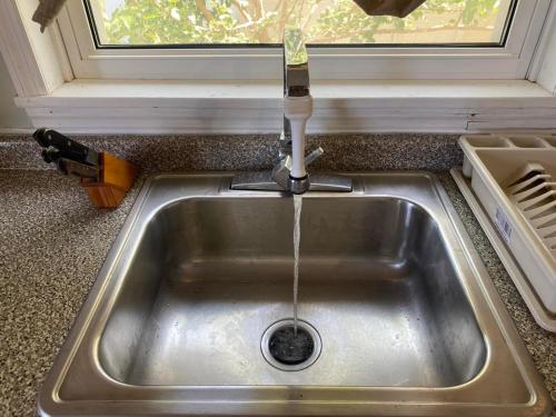 um lavatório de cozinha com água a correr de uma torneira em Stergios Apartment Evdilos Ikaria em Evdilos