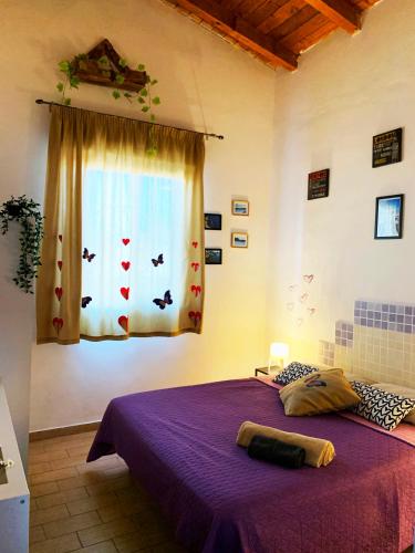 a bedroom with a purple bed and a window at Villa Viola in Agnone Bagni