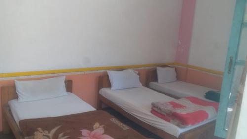 two twin beds in a small room with at Hotel Chitral Continental in Chitral