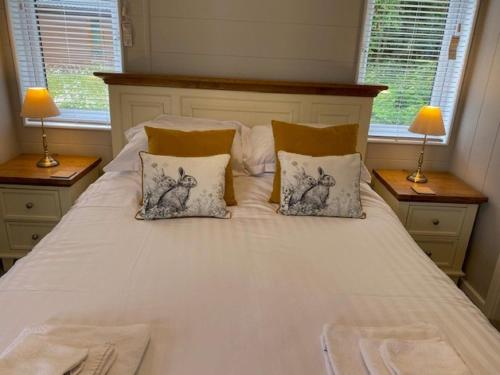 a white bed with two pillows and two windows at Hollicarrs - Sunflower Lodge in York