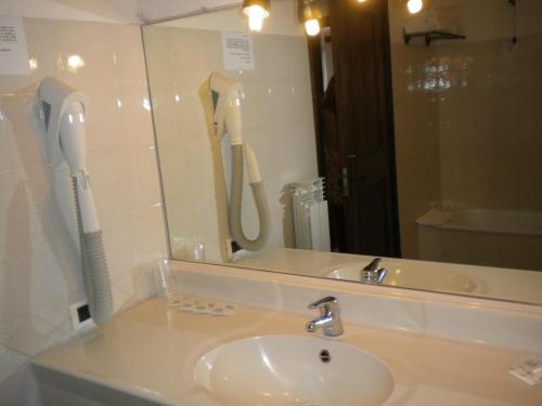 bagno con lavandino, specchio e telefono di Hotel Tavernier a Courmayeur
