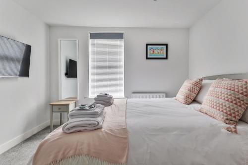 a bedroom with a bed with towels on it at Finest Retreats - 13 Belle House - Apartment 2 in Filey