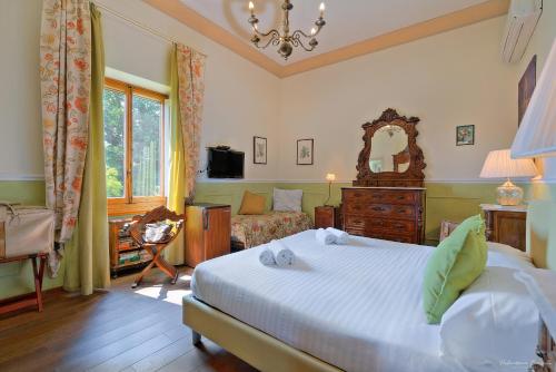 a bedroom with a bed and a couch and a mirror at Villa Ape Rosa Relais in Florence