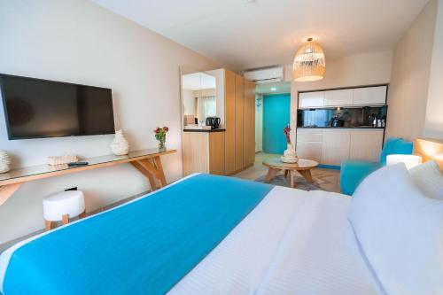 a bedroom with a blue and white bed and a tv at Redcon Suites in Hurghada