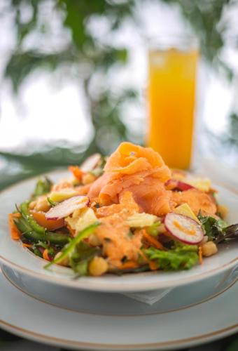 a plate of food with a salad and a glass of orange juice at Solar Do Conde Garden Hotel in Capelas