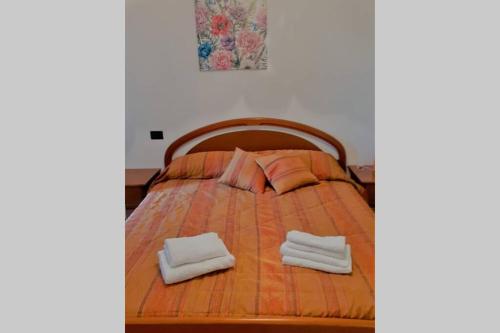 a bed with two pillows and two towels on it at Feel at Home - CASA LOREDANA in Lovere