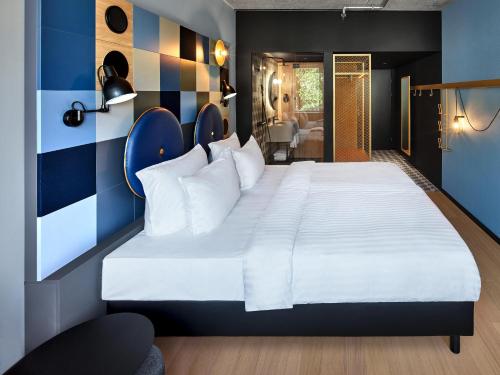 a hotel room with a large bed and a large mirror at Jaz in the City Vienna in Vienna