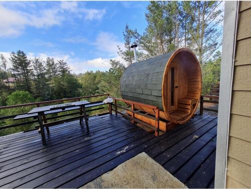 a wooden deck with a sauna and a bench on it at Cabaña Refugio Sauna Spa El Arrayan Casablanca Valdivia in Valdivia