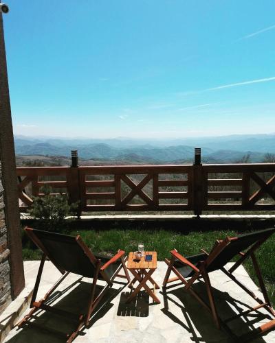 two chairs and a table in front of a fence at Vila Rajski kutak Kopaonik in Kopaonik