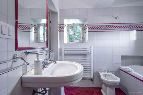 a white bathroom with a sink and a toilet at Villa Ape Rosa Relais in Florence