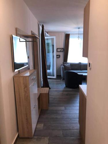 a hallway of a living room with a television and a couch at LIDO nappali + 3 háló apartman in Balatonlelle