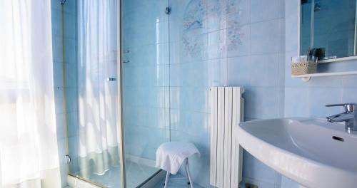 y baño azul con lavabo y ducha. en Villa Cavour, en Bottanuco
