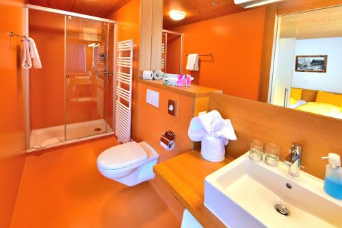 een oranje badkamer met een toilet en een wastafel bij Hotel Wetterhorn in Grindelwald